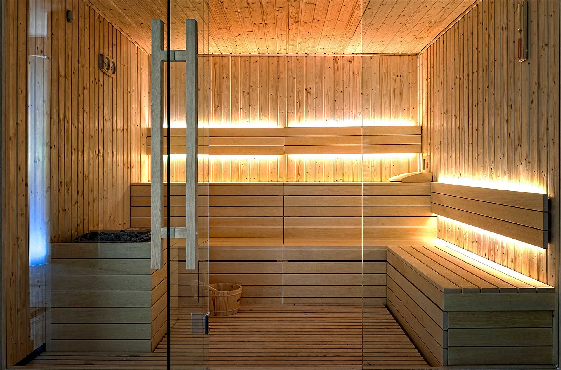 Large-Sauna-Feature Large custom sauna featuring large glass wall and light pine wood
